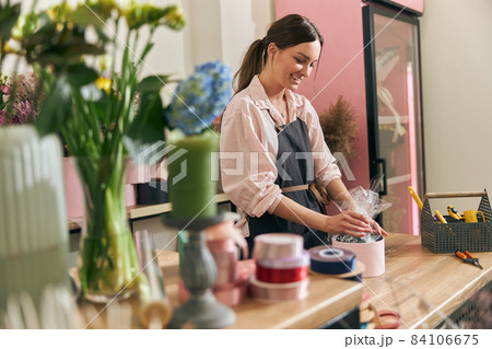 Professional florist young woman is doing bouquets at flower shop 84106675