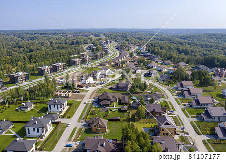 Aerial view of a cottage village on the edge of an endless forest in Siberia 84107177