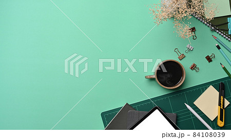 Above view cup of coffee, digital tablet and stationery on green background. Above view cup of coffee, digital tablet and stationery on green background. 84108039