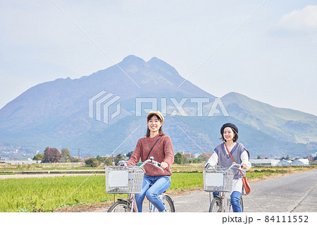 自転車で湯布院を散策する若い女性と友達 84111552