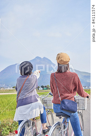 自転車で湯布院を散策する若い女性と友達 84111574