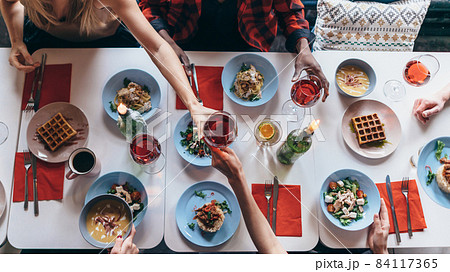 People are sitting at a table and eating. Top view People are sitting at a table and eating. Top view 84117365