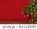 red background, christmas tree, spruce branches with New Year's toys, background for a New Year card 84118099