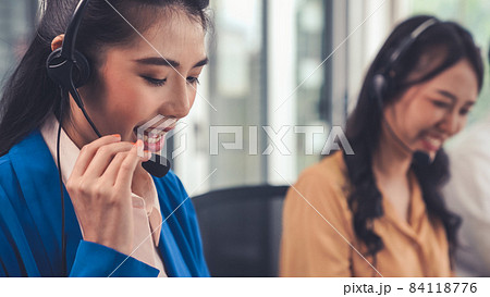 Businesswoman wearing headset working actively in office Businesswoman wearing headset working actively in office 84118776