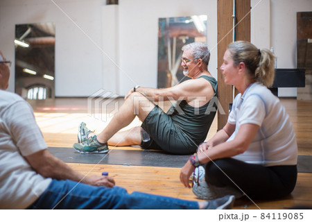 Smiling senior dance students resting on floor Smiling senior dance students resting on floor 84119085