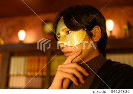 書斎で仮面を着けた男性 84124386