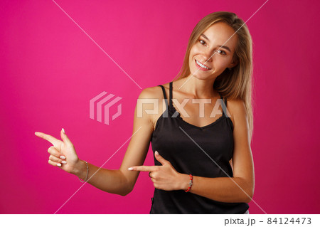 Portrait charming pretty cheerful girl showing copy space Portrait charming pretty cheerful girl showing copy space 84124473
