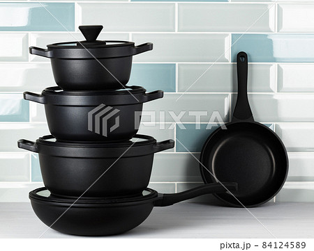 New black cookware against blue tile wall New black cookware against blue tile wall 84124589