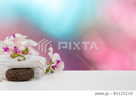 Towels with flowers on light table against blurred background Towels with flowers on light table against blurred background 84125219