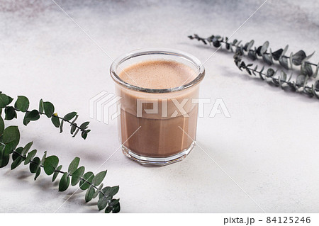 Raf coffee coffee steamed with cream eucalyptus behind on grey Raf coffee coffee steamed with cream eucalyptus behind on grey 84125246