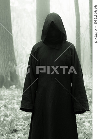 Death in a black hoodie mantle in forest mistery fog. Horror style fear spooky evil 84126696
