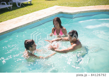 Cheerful friends swimming in pool Cheerful friends swimming in pool 84126792
