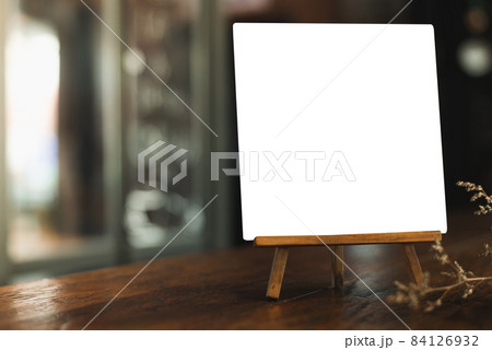 Menu with isolated white on wooden table on blurred coffee shop background. Menu with isolated white on wooden table on blurred coffee shop background. 84126932