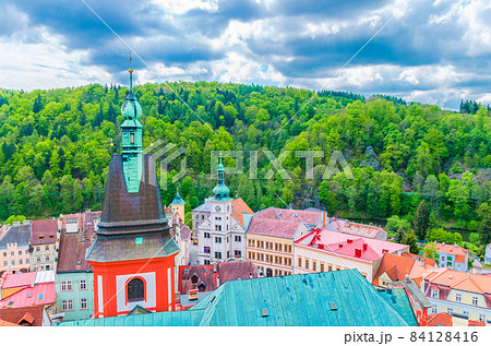 Top aerial view of St Wenceslas gothic Church spire and colorful traditional typical buildings of Loket town 84128416
