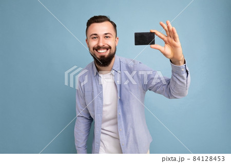 Photo of good looking attractive positive happy smiling brunet unshaven young man wearing casual 84128453