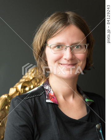 Portrait of thirty year old woman sitting on a chair inside 84129243