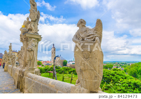 Baroque statues of saints and the Church of St James catholic church building with clock tower 84129473