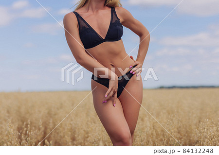 A young woman in underwear in a field of wheat. A young woman in underwear in a field of wheat. 84132248