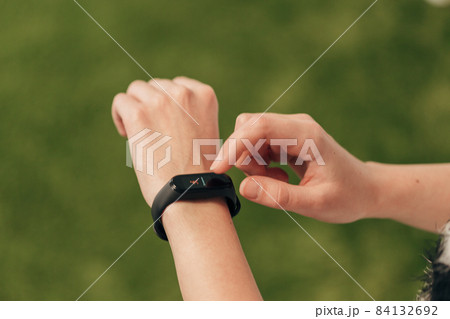 The girl will measure her heartbeat on a smart watch. Checking pulse. 84132692