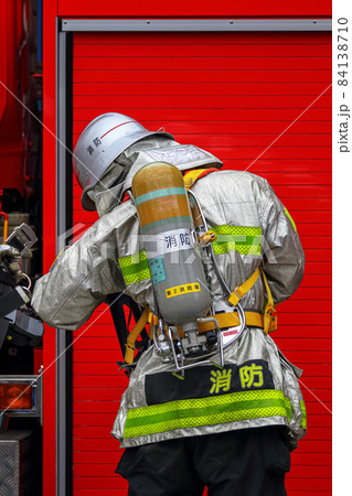 酸素ボンベ、防火服などフル装備で出動準備をする消防隊員 84138710