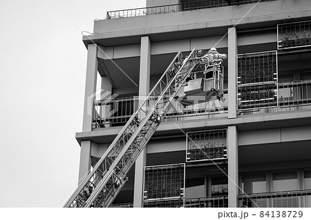 しごを伸ばしバスケットの中で救助活動訓練を行う消防士 84138729