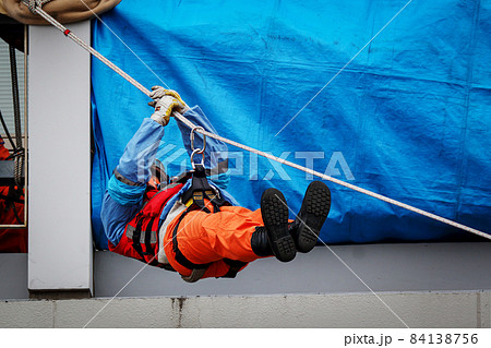 レスキュー隊員による綱渡りで救助活動を行う消防訓練 84138756