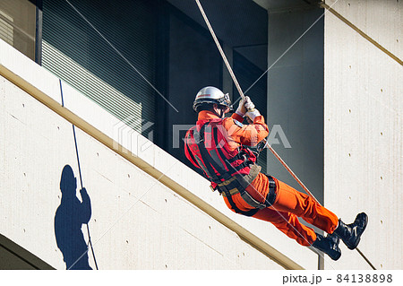 レスキュー隊員による綱渡りで救助活動を行う消防訓練 84138898