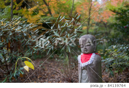 秋の晴天に紅葉が色ずく山と地蔵さんの風景 84139764