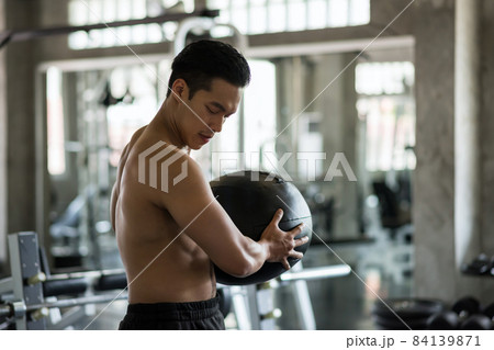 Asian man exercise abdomen ball in gym Asian man exercise abdomen ball in gym 84139871