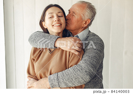 Elegant old man standing at home with his granddaughter 84140003