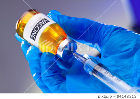 Covid-19 vaccine bottle with a syringe taking the vaccine from it Covid-19 vaccine bottle with a syringe taking the vaccine from it 84143515