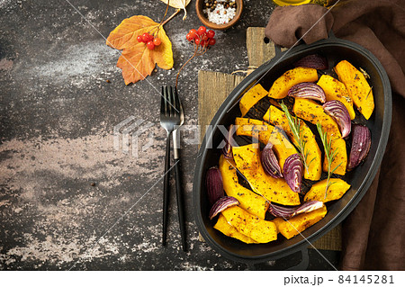Pumpkins slice with rosemary and purple onion, baking fresh healthy food with spice on a dark stone background. Keto or paleo diet veggie vegan or vegetarian. Top view flat lay background. Copy space. Pumpkins slice with rosemary and purple onion, baking fresh healthy food with spice on a dark stone background. Keto or paleo diet veggie vegan or vegetarian. Top view flat lay background. Copy space. 84145281