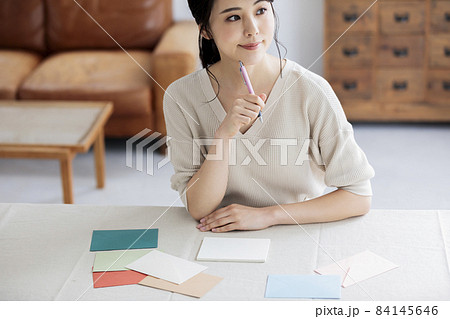 窓辺で手紙を書く若い女性 84145646