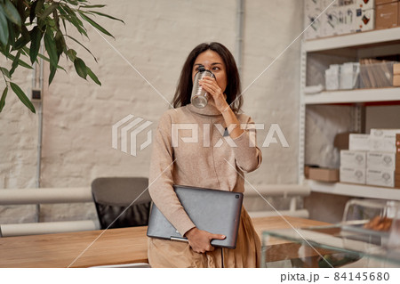 Woman with netbook having coffee break Woman with netbook having coffee break 84145680