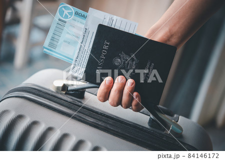 People holding passports and Coronavirus vaccination record card, map for travel with luggage for the trip. Covid-19 around the world 84146172