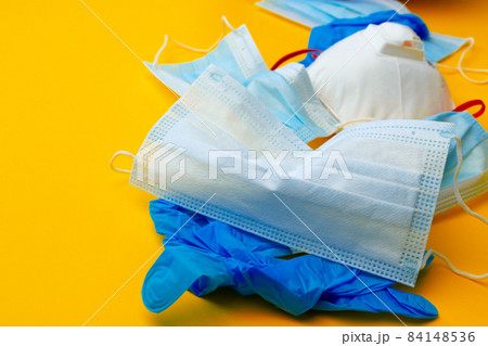 Protective equipment, masks and gloves, on an orange background Protective equipment, masks and gloves, on an orange background 84148536