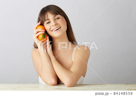 wellness woman with tangerine in her hands 84148559