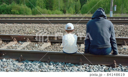 Photo of the girl and boy sitting on rails 84148619