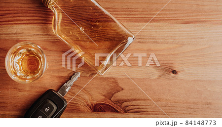 Close up of car keys and strong rum on the table, do not drink and drive, alcohol concept Close up of car keys and strong rum on the table, do not drink and drive, alcohol concept 84148773