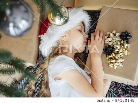 The little girl lies under the tree and dreams. The little girl lies under the tree and dreams. 84150149