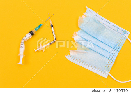 Broken Medical Syringe and Torn Medical Face Mask Broken Medical Syringe and Torn Medical Face Mask 84150530