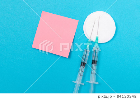 Vaccination or Revaccination Concept - Two Medical Syringe on Blue Table Vaccination or Revaccination Concept - Two Medical Syringe on Blue Table 84150548