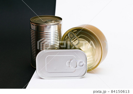 A Group of Stacked Tin Cans with Blank Edges on Split Black and White Background A Group of Stacked Tin Cans with Blank Edges on Split Black and White Background 84150613
