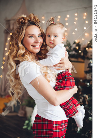 Smiling pretty woman holding her baby with 84151841
