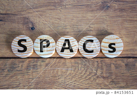 SPACs symbol. Wooden circles with words 'SPACs, special purpose acquisition companies' on beautiful wooden background, copy space. Business and SPACs concept. 84153651