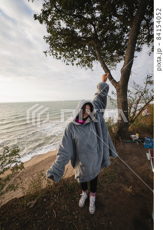 Young woman on cold autumn seashore posing at camera 84154052