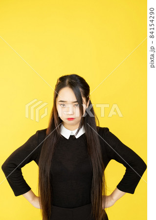 Offended woman. Displeased expression. Negative emotion. Unhappy frowning upset girl isolated on yellow empty space studio background. 84154290
