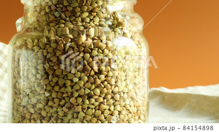 Green sprouts of raw organic buckwheat in a glass jar for cereals. Vegan food concept. Organic food. The concept of diet, weight loss, healthy and proper nutrition. Copy space for text. Green sprouts of raw organic buckwheat in a glass jar for cereals. Vegan food concept. Organic food. The concept of diet, weight loss, healthy and proper nutrition. Copy space for text. 84154898
