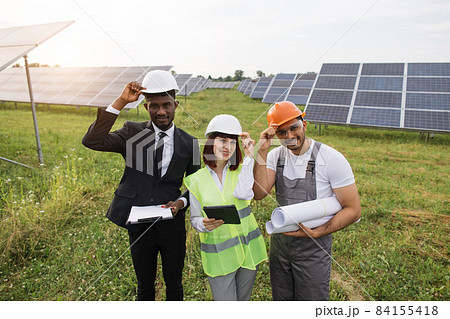 Two inspectors and foreman smiling on camera at solar farm Two inspectors and foreman smiling on camera at solar farm 84155418