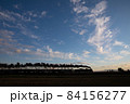 夕日を浴びて力強く走るSLのシルエット 84156277